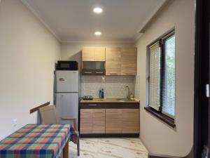 a small kitchen with a table and a refrigerator at Hotel Sataplia in Banoja