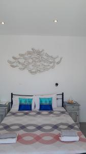 a bedroom with a large bed with blue pillows at Amazing Room on the Cliff in Imerovigli