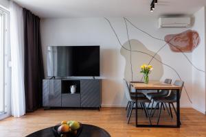 a living room with a table and a tv at Split For You - 2BR Apartment with Free Garage Parking in Split