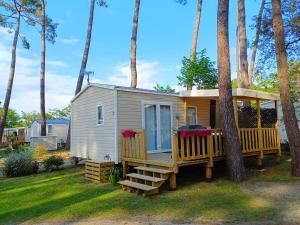 塞尼奥斯MOBIL HOME à SEIGNOSSE dans les Landes près de la mer的带门廊和露台的小房子