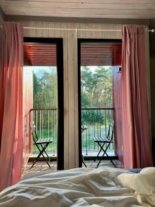 a bedroom with a bed and a balcony with chairs at Sunny family holiday home in Jurmala in Jūrmala