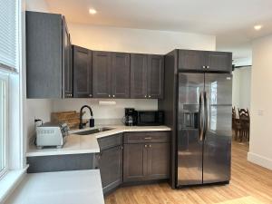 una cucina con mobili in legno e un frigorifero in acciaio inossidabile di Main Street Retreat in Sunapee a Sunapee