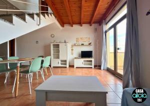 a living room with a table and green chairs at Casa Alicia - El Cotillo - 2 Camere, 2 Bagni in El Cotillo