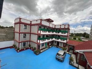 EmbakasiDynamic Fully Furnished Apartments in Nairobi, 14 km from Jomo Kenyatta International Airport and the SGR的一栋建筑前停着一辆车