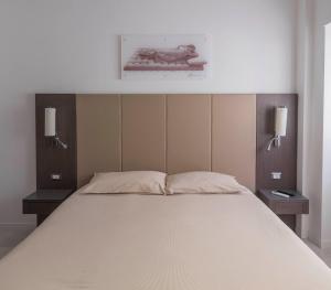 a bedroom with a bed with two lights on the wall at Il Perugino Guest House in Rome