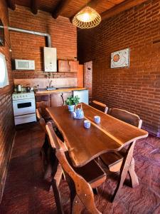 een keuken met een houten tafel en stoelen in een kamer bij Quebrada del Viento - Cabañas in Los Hornillos