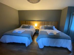 a bedroom with two beds with towels on them at H Molle in Cafayate