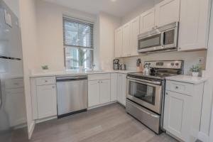 a kitchen with white cabinets and stainless steel appliances at Luxury at 2br 2ba 200mbps Internet in Boston +5 photos