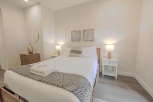 a bedroom with a large white bed and two lamps at Luxury at 2br 2ba 200mbps Internet in Boston