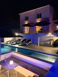 una villa con piscina por la noche en Starblue VILLA 172m2 - Mer et spa, en Carry-le-Rouet