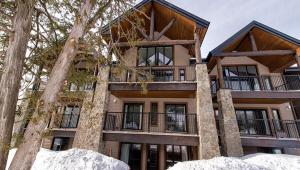 a large building with trees in front of it at Luxurious mountainside condo - Ski-Waterslide - Domaine Nymark in Saint-Sauveur-des-Monts