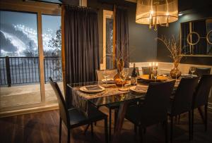 a dining room with a table and chairs and a window at Luxurious mountainside condo - Ski-Waterslide - Domaine Nymark in Saint-Sauveur-des-Monts +6 photos