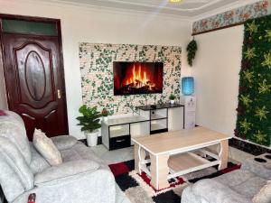 EmbakasiDynamic Fully Furnished Apartments in Nairobi, 14 km from Jomo Kenyatta International Airport and the SGR的客厅的墙上设有壁炉