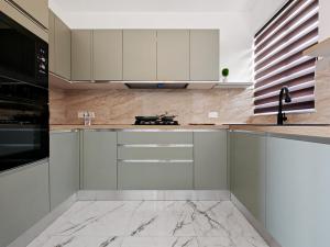 a kitchen with white cabinets and a marble floor at SkyHaus in Fgura