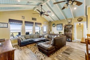 a living room with leather furniture and a ceiling fan at Ocean View Elevator PetFriendly Games Beach Access in Bolivar Peninsula