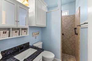 a bathroom with a toilet and a sink and a shower at Ocean View Elevator PetFriendly Games Beach Access in Bolivar Peninsula +41 photos
