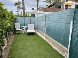 a patio with two chairs and a table on a fence at Descubre el bungalow perfecto para tus vacaciones in San Bartolomé de Tirajana