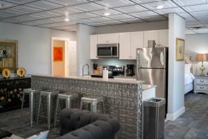 a kitchen with a bar with stools and a refrigerator at Upstairs Villa at Pine Street in Eureka Springs