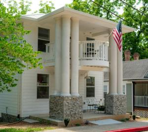 a house with columns and an american flag at Springs WishDowntown Historic Loop Downstairs King Free Parking in Eureka Springs