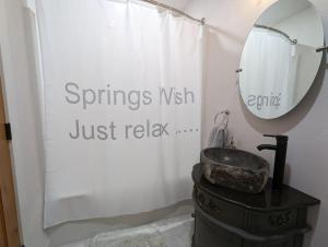 a bathroom with a sink and a mirror at Springs WishDowntown Historic Loop Downstairs King Free Parking in Eureka Springs