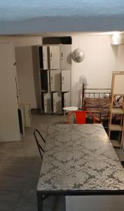 un soggiorno con tavolo e sedie e una camera con una camera di The Rabbit Hole Hostel Fira a Firà