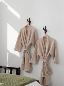 two coats are hanging on a wall at Welcome to the Milky Wayfarer in Marfa