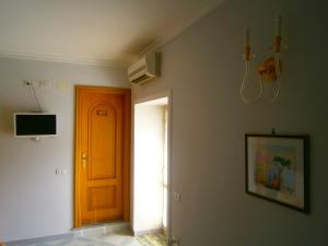 a hallway with a door and a television on the wall at Villa En Rose in Ravello