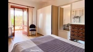 a bedroom with a bed and a dresser and a window at 5minutos do jardim até ao mar in Parede