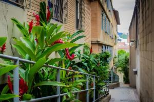an alley with red flowers next to a building at 4let BH Del Rey in Belo Horizonte