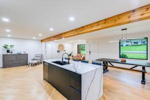 an open kitchen and living room with a ping pong table at Spacious Deck Contemporary Home in Nashville! in Nashville