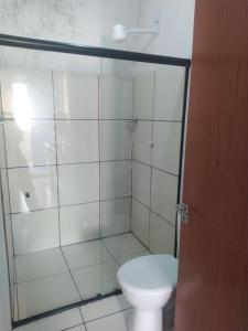 a bathroom with a toilet and a glass shower at Ice Flat Comfort in Garanhuns +3 photos