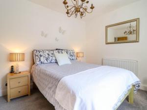 a bedroom with a bed and a mirror and a chandelier at Dola in Betws-y-coed