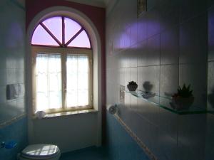a bathroom with a toilet and a window at Villa En Rose in Ravello
