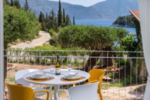 a table and chairs on a balcony with a view at Foki Beach House in Fiskardo