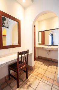 La salle de bains est pourvue d'un miroir et d'une chaise en bois. dans l'établissement Hotel Arboledas Industrial, à Guadalajara