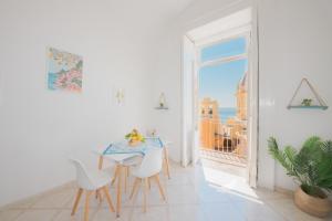 a white room with a table and chairs and a window at La Casa di Maddalena - Historic center VIEW in Procida