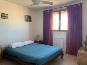 a bedroom with a bed and a window with purple curtains at Villa provençale pour 4 adultes et 2 enfants in La Londe-les-Maures