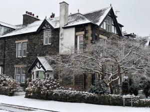 a large brick house with snow on the ground at Kirkwood Guest House in Windermere