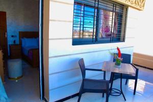a table and chairs in a room with a bedroom at Moonrise Villa VIP Midelt in Midelt