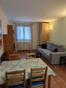 a living room with a couch and a table and chairs at Casa espelunciecha in Biescas