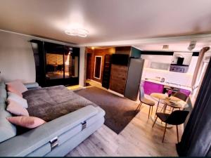 a bedroom with a bed and a table and a kitchen at Stone city center ІІ in Kamianets-Podilskyi