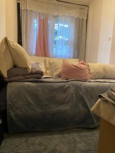 a bed with pillows on it in front of a window at Zoldovezet in Budaörs +10 photos