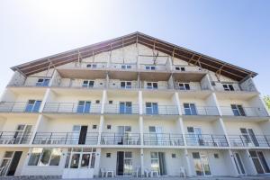 a large white building with a balcony at Vila Cornelius in Costinesti +35 photos