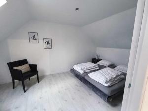 a bedroom with a bed and a chair at Gîte la prairie in La Chapelle-Huon +3 photos