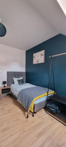 een slaapkamer met een bed en een blauwe muur bij Enjoy en Champagne maison calme au milieu du vignoble avec parking gratuit in Dormans