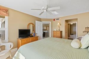 une chambre avec un lit et une télévision à écran plat dans l'établissement Direct oceanfront corner condo with spacious balcony and heated beachfront pool, à Ormond Beach