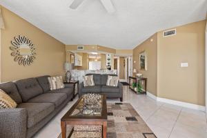 un salon avec un canapé et une table dans l'établissement Direct oceanfront corner condo with spacious balcony and heated beachfront pool, à Ormond Beach