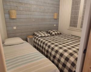 zwei Betten, die in einem Zimmer nebeneinander stehen in der Unterkunft Ossau T2 5 personnes piscine climatisation 1 chambre draps serviettes inclus parking moustiquaires lave vaisselle lave linge tout confort in Bielle