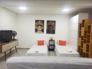 a room with two beds and a tv in it at Ap super espaço próximo a 25 de março in Sao Paulo