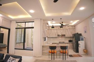a kitchen with a counter and stools in a room at Mirpur Modern Spanish Villa - Elegant Comfort in the Heart of the City in New Mīrpur